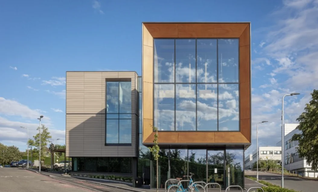 Contemporary building with a large glazed facade reflecting the sky