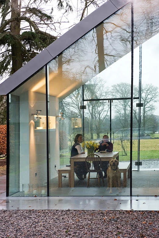 Dining space seen through the full-height glazing at Highland Retreat