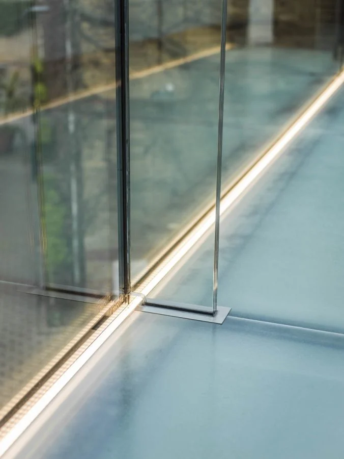 Glass wall junction and illuminated floor edge inside the bridge