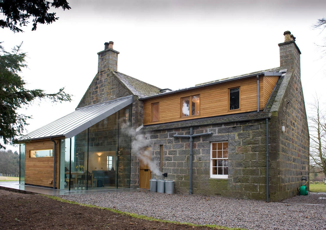 Rear view of Highland Retreat showing the glass extension beside the stone house