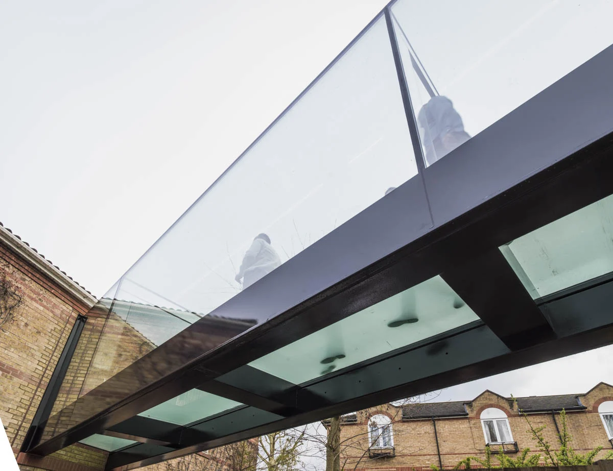 View beneath the glass bridge showing glass floor panels