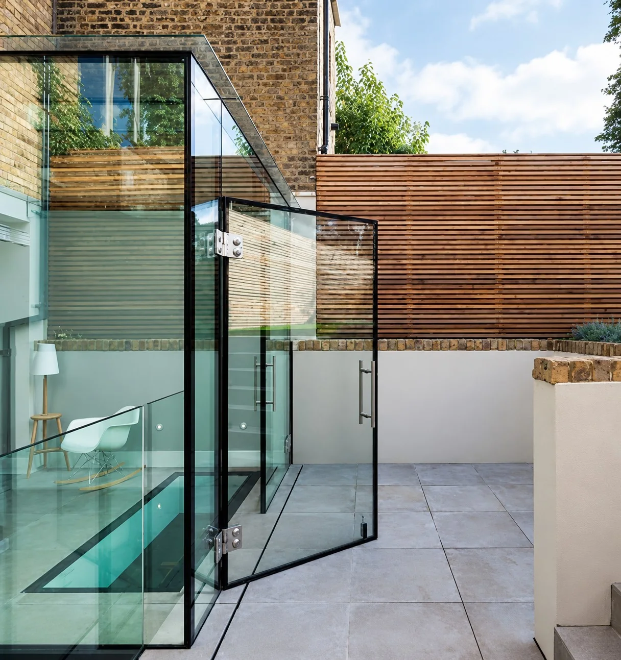Frameless glass doors opening from St James onto the courtyard
