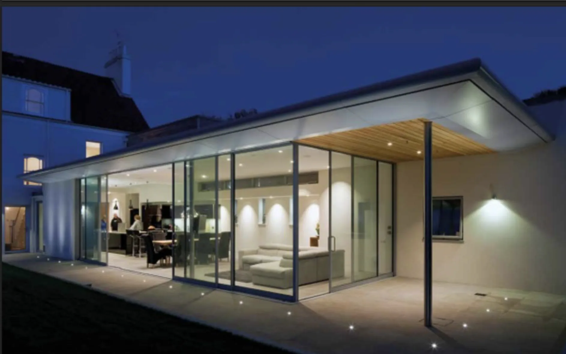 Glazed extension viewed from the terrace, showing glass doors around the corner